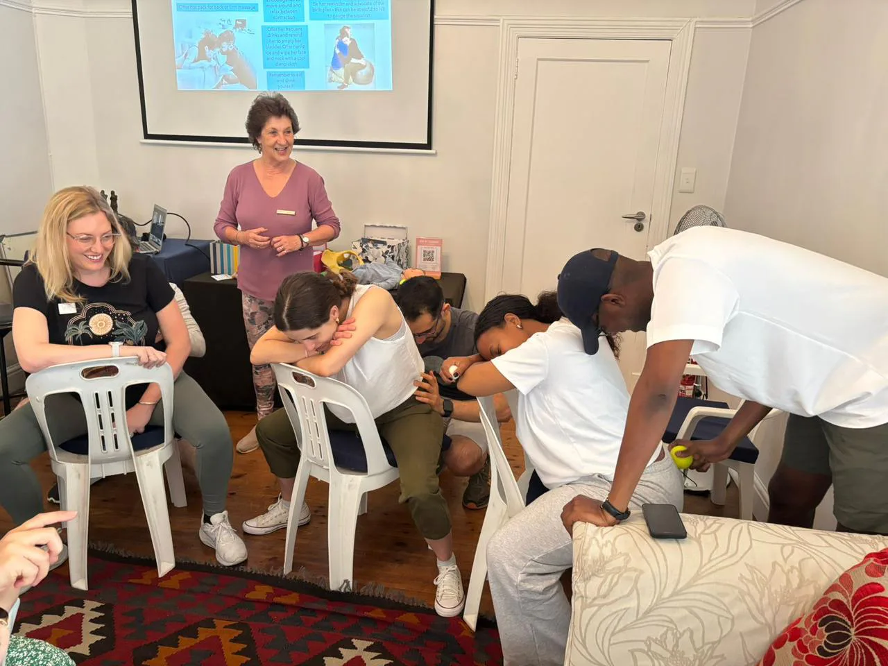 Birth partners practising labour positions and back massage during a class