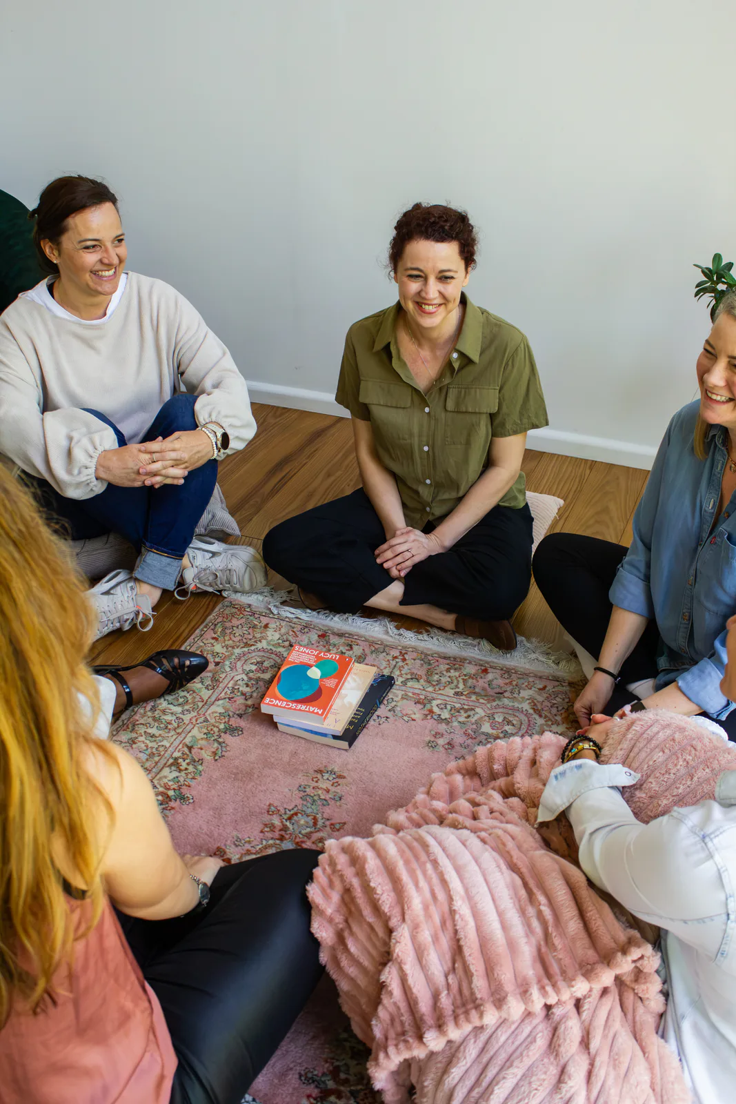 Mothers sitting in a circle on the floor during a Mothermorphosis group session