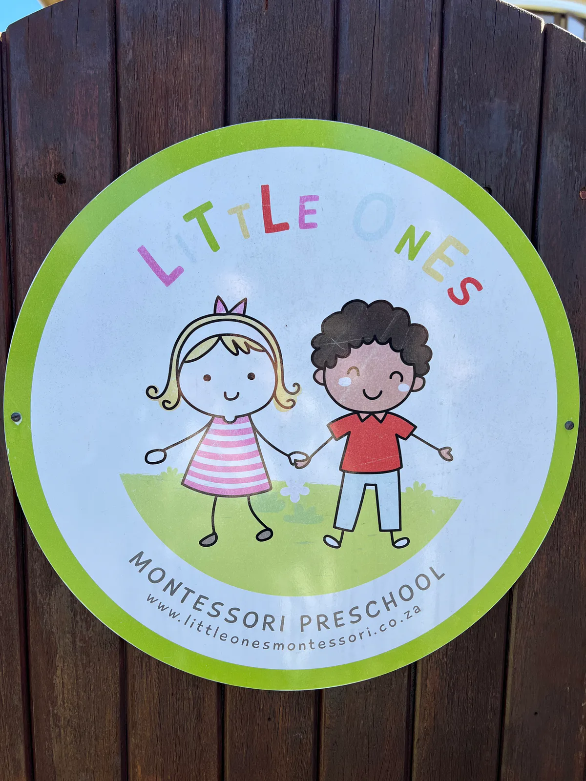 The Little Ones Montessori Preschool sign on the garden gate