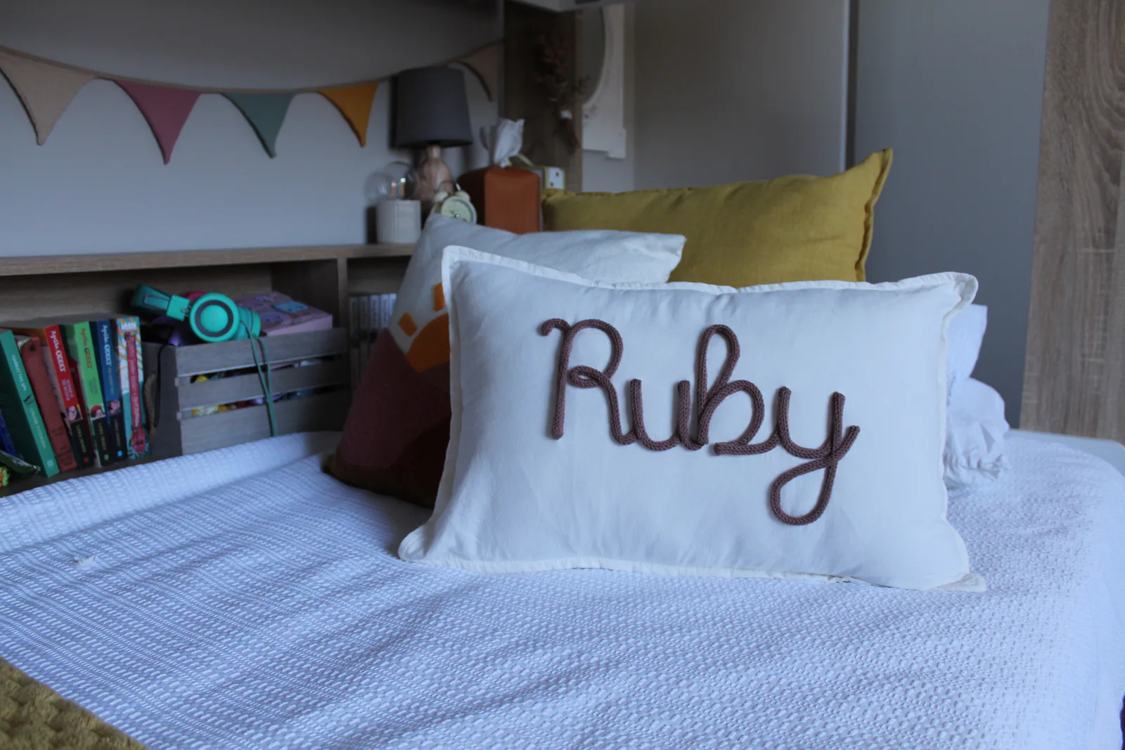 Ruby knitted name cushion in a child’s bedroom